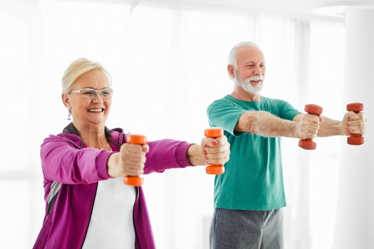an older couple using free weights at home